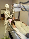 Skeleton taking an x-ray of a man.